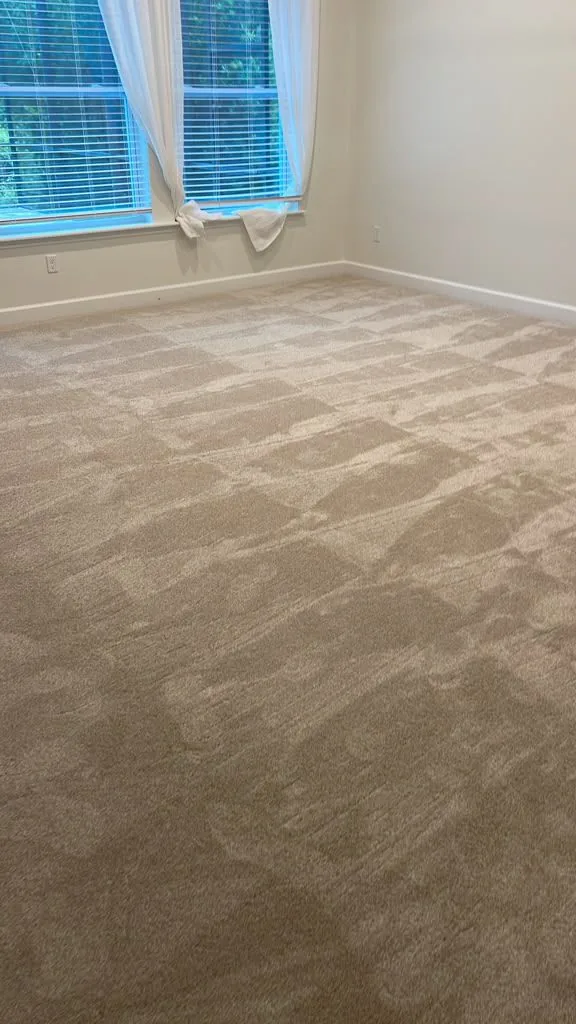 Beige carpet in a bedroom lit by a curtained window