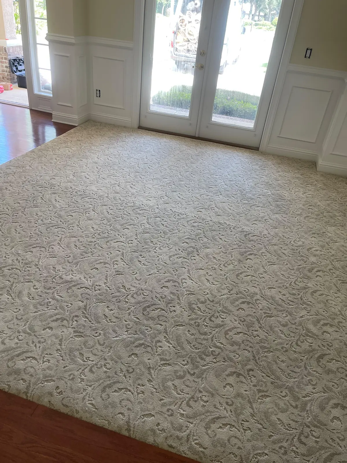 Cream patterned carpet in a formal room with french doors