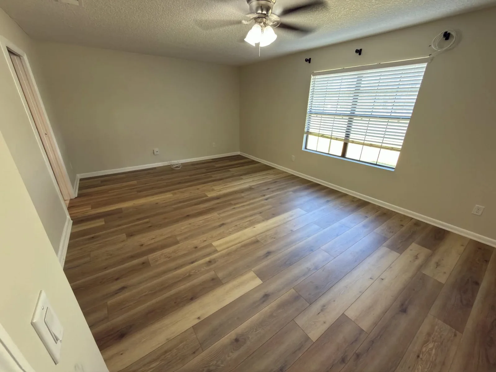 Laminate plank flooring in a living room with a ceiling fan